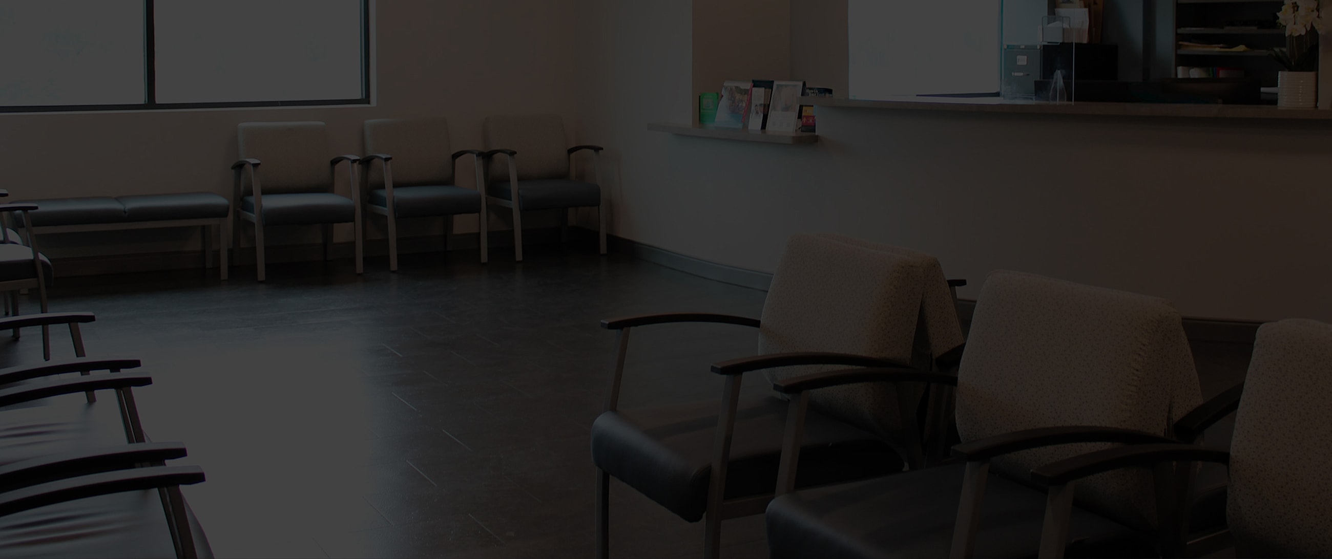 Empty waiting room with chairs and a counter.