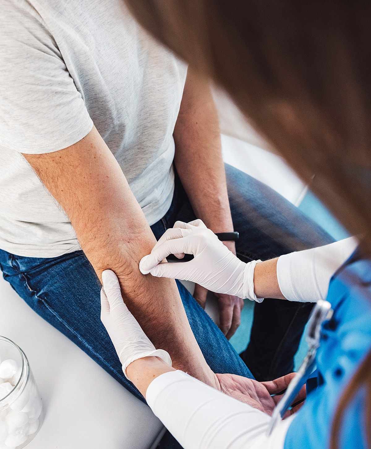 Person receiving a medical procedure on arm.