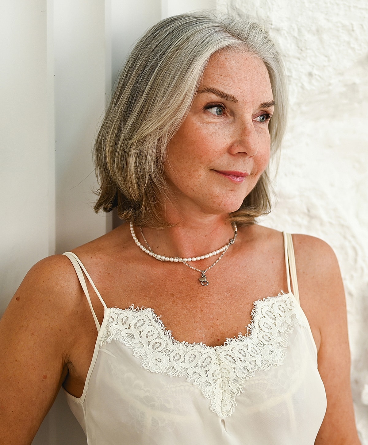 Woman with gray hair in lace top.