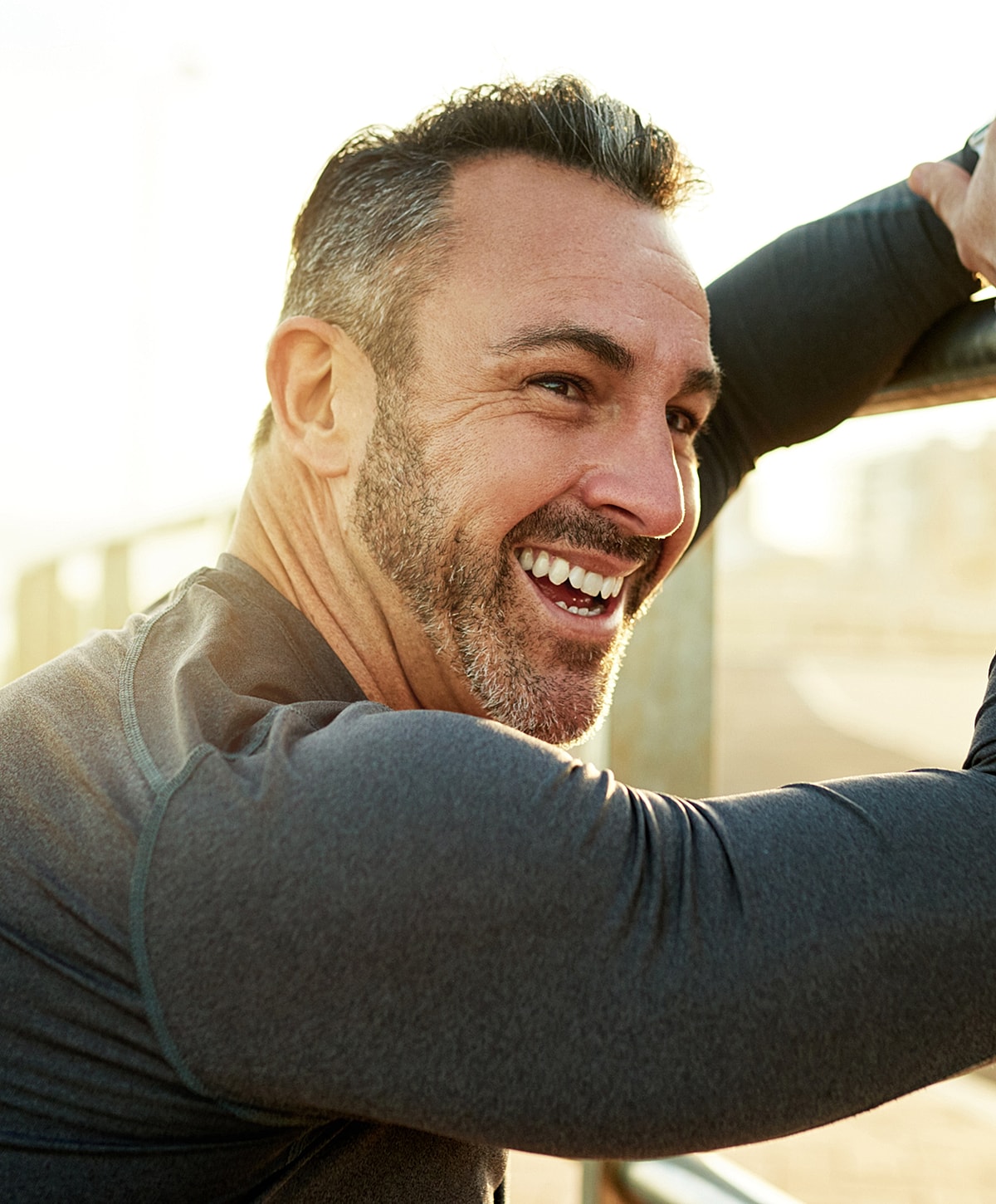 Smiling man outdoors in fitness clothing.