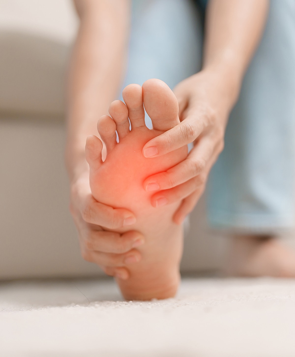 Person grabbing foot, experiencing pain or discomfort.