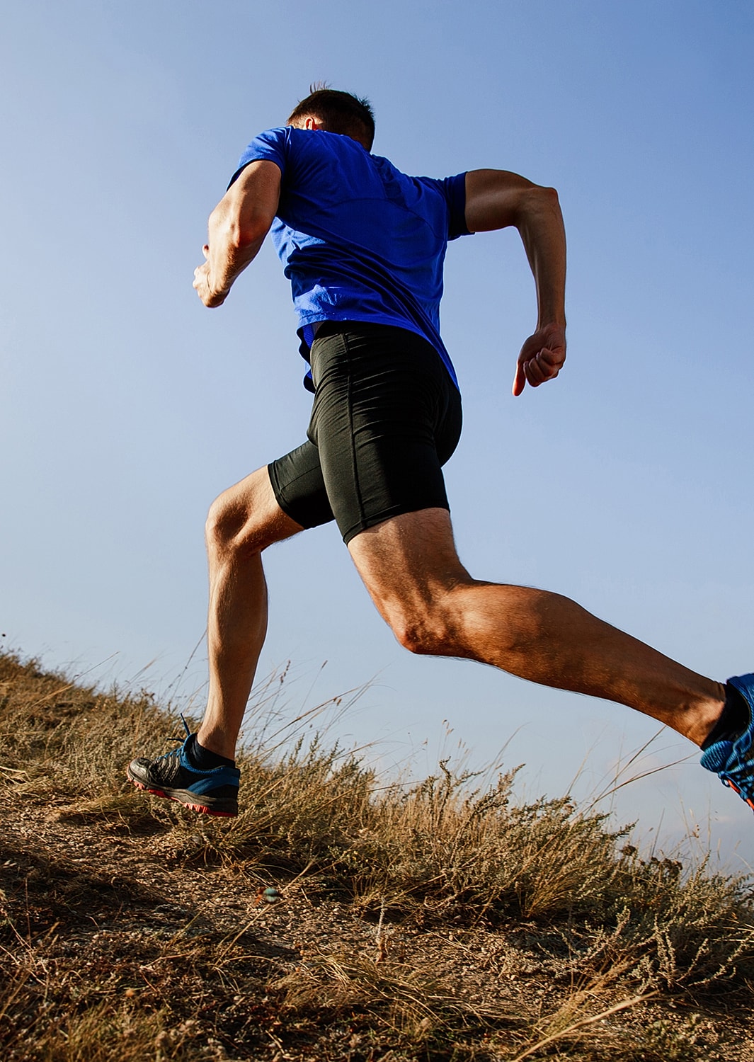 Person running uphill in athletic clothing.