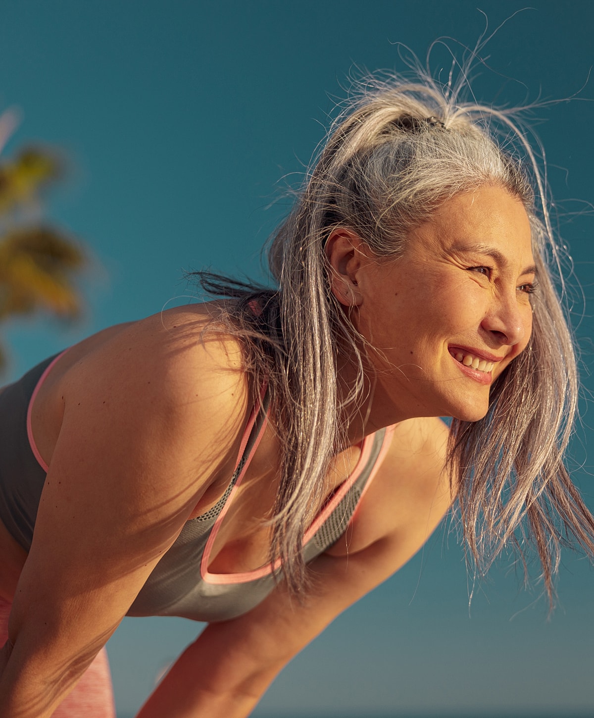 Man exercising on rowing machine, smiling happily.