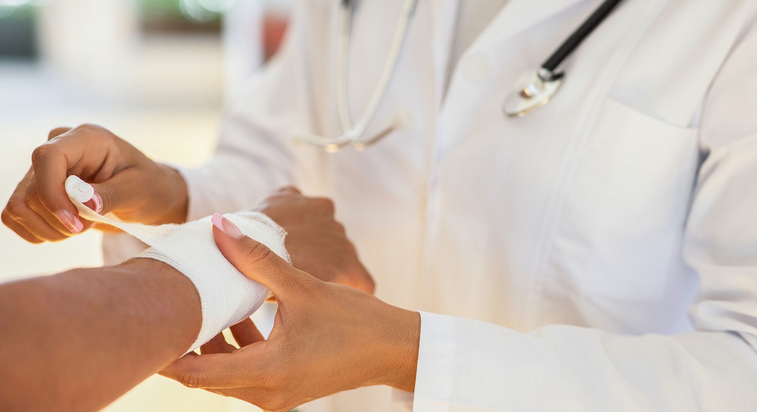 Medical professional wrapping a patient's injury.