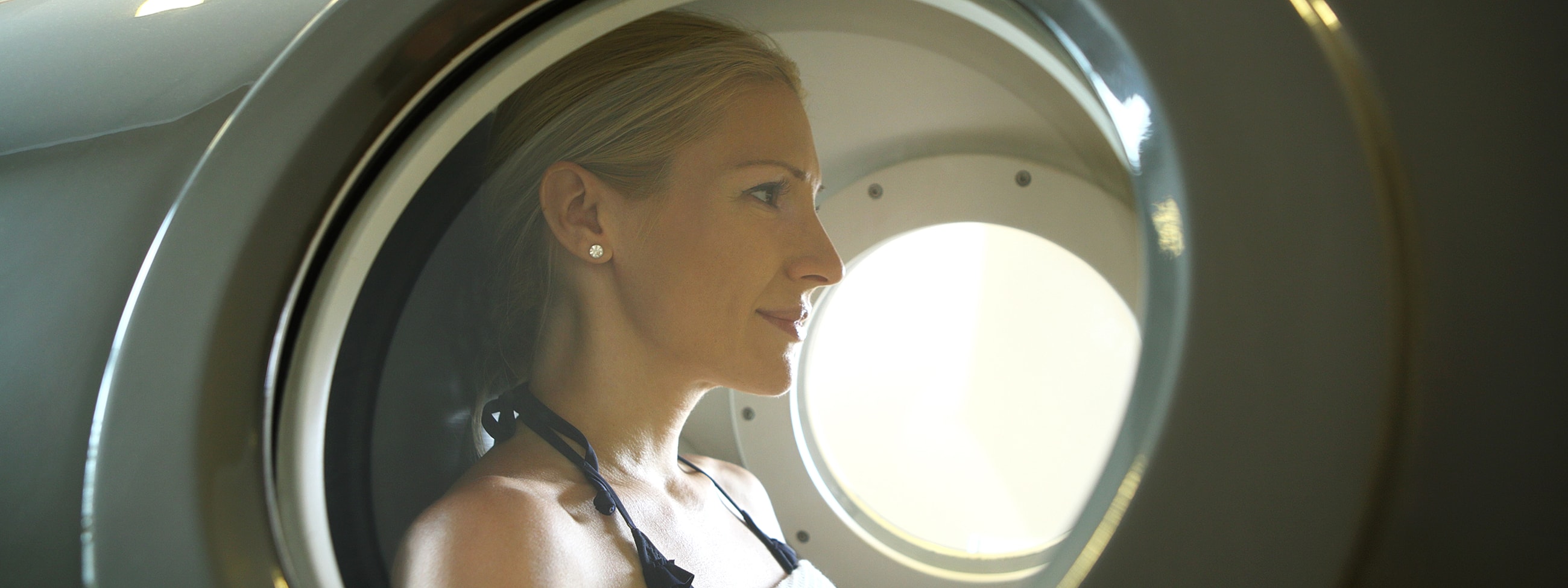 Woman looking out from a circular window.