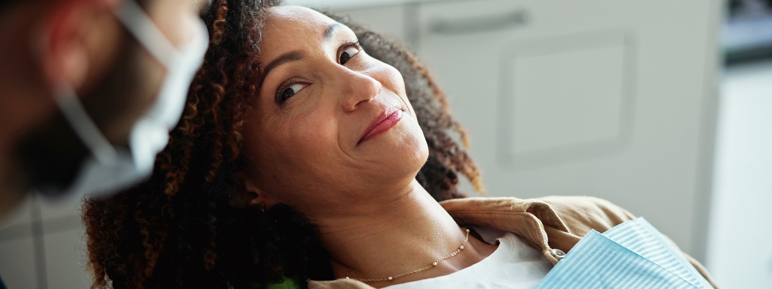 Woman smiling in dental office, preparing for treatment.