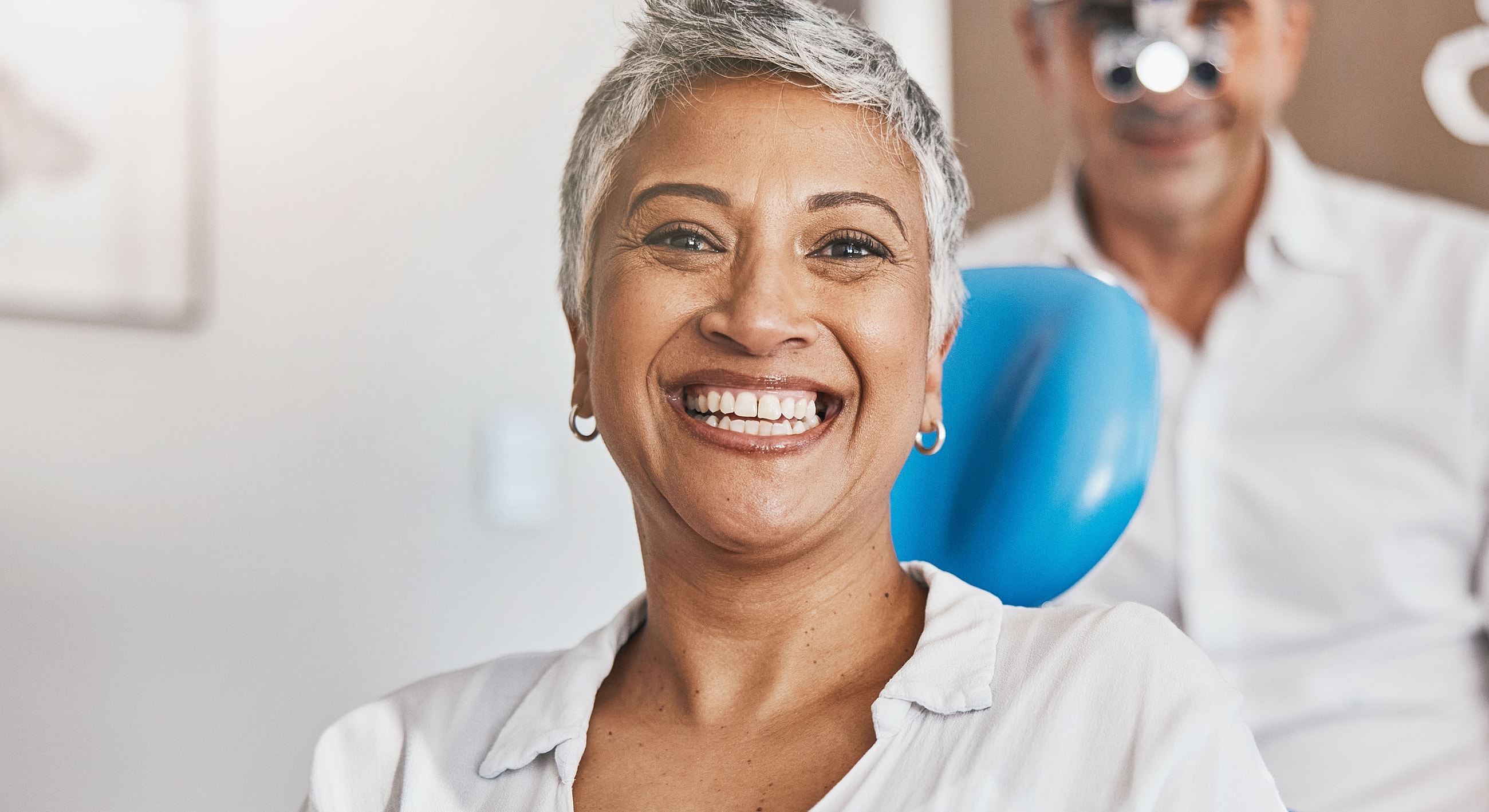 Woman smiling at dentist appointment, relaxed atmosphere.