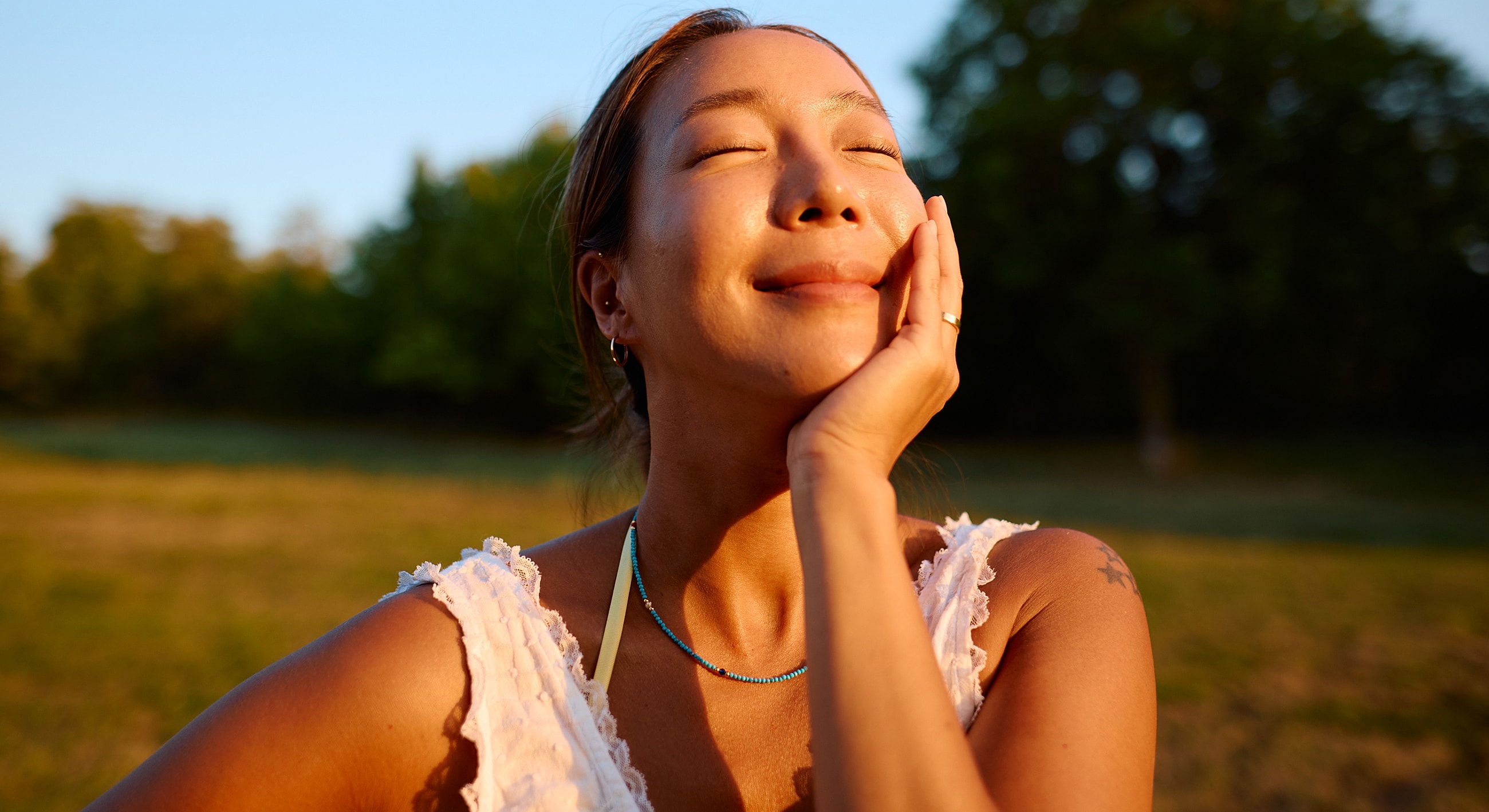 Woman enjoying the sun in a serene landscape.