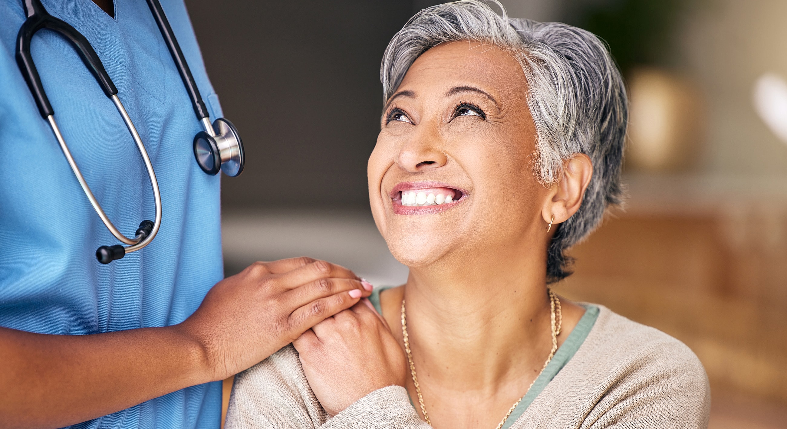 Smiling patient with caregiver in medical setting.