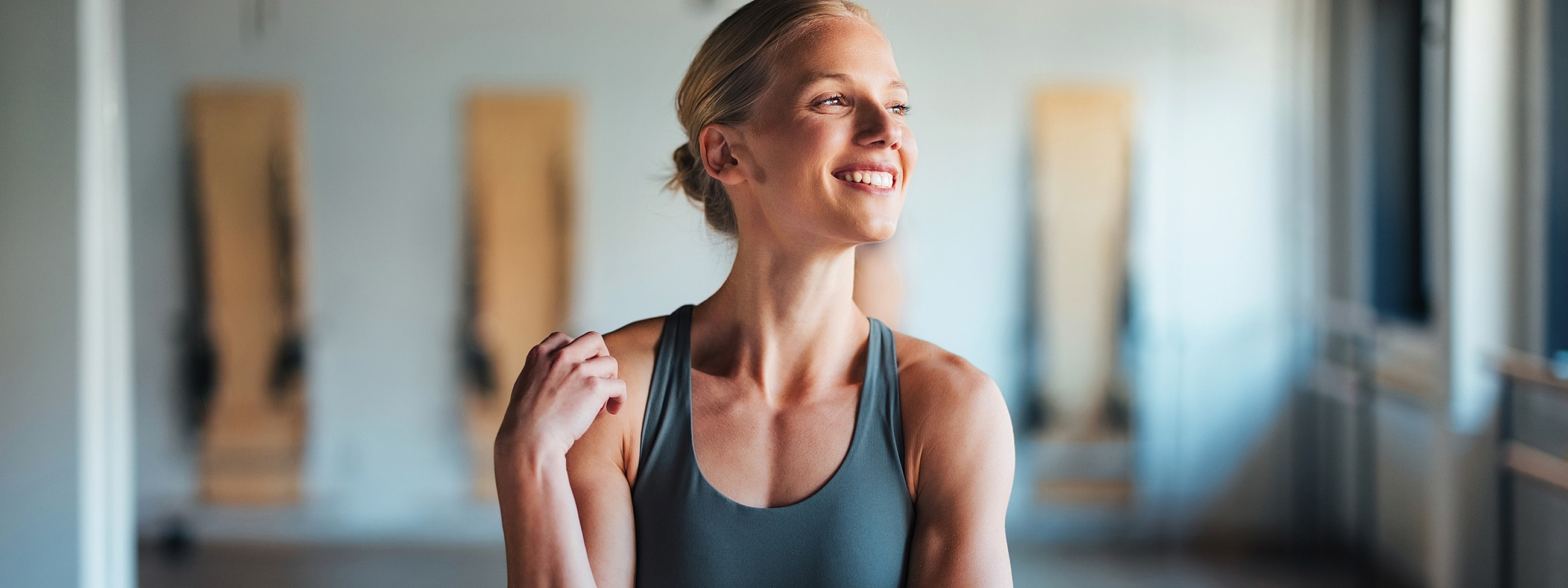 Smiling woman in athletic wear indoors.